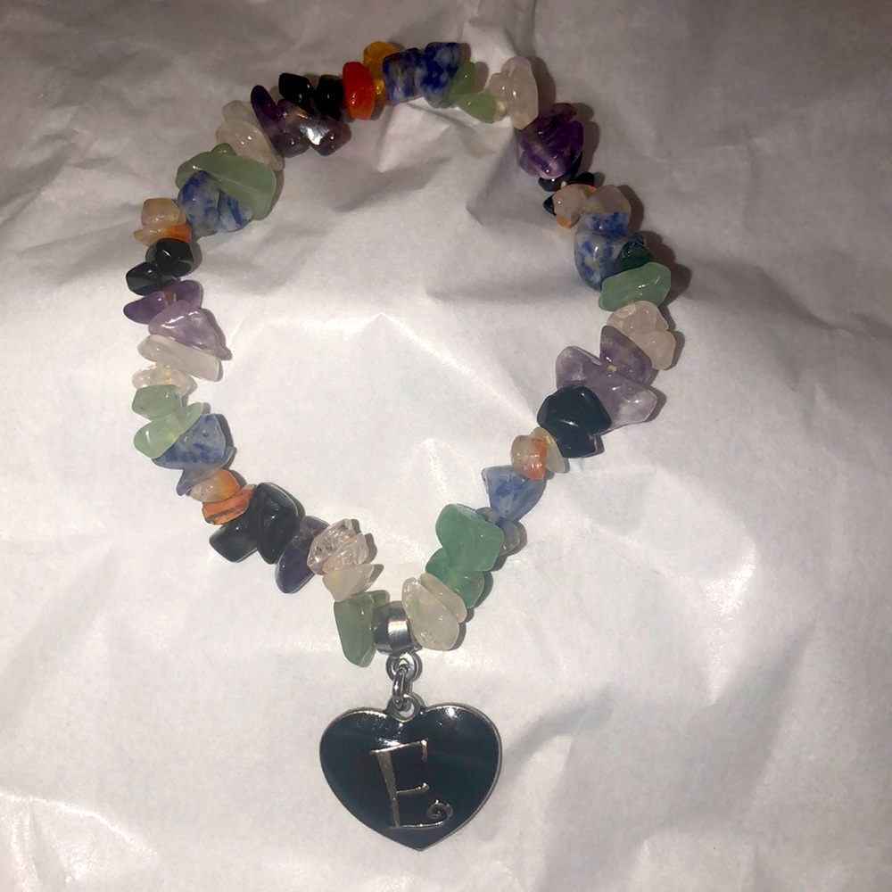 Cute stretch mineral rock bracelet with a black heart and the letter E on it.